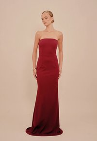 Axelbandslös sjöjungfruklänning i vinröd tyg, figursydd överdel med släta linjer, golvlång design, slät textur, minimal detaljer.