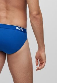 Blaue Baumwollunterhose mit einem kontrastierenden weißen "BOSS"-Logo am Bund und einer glatten Oberfläche. Das Design bietet eine enge Passform und elastisches Material.