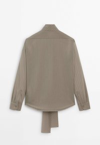 Chemise à manches longues marron clair à fines rayures, avec poignets à boutons et une pièce de tissu étendue pendue à l'ourlet arrière.