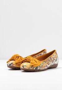 Baleriny z kolorowym, teksturowanym wierzchem, z żółtą, związaną kokardą na czubku. Gumowa podeszwa, okrągły kształt i miękka podszewka.