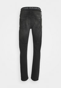Černé džíny z denimu s rovnými nohavicemi, se zvláštním páskem s logem "CALVIN KLEIN JEANS" a dvěma zadními kapsami.