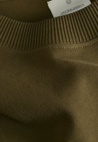 Pull olive avec un col côtelé, une texture de tissu lisse et une étiquette avec le nom de la marque "Jack & Jones."
