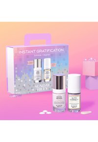 Ensemble de deux produits de soin de la peau dans des flacons en verre : un Good Genes blanc avec un capuchon argenté et un Auto Correct transparent avec un capuchon blanc, présentés dans une boîte colorée.