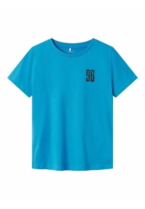 Camiseta de algodón turquesa con cuello redondo y mangas cortas. Presenta un estampado gráfico negro en la parte izquierda del pecho.