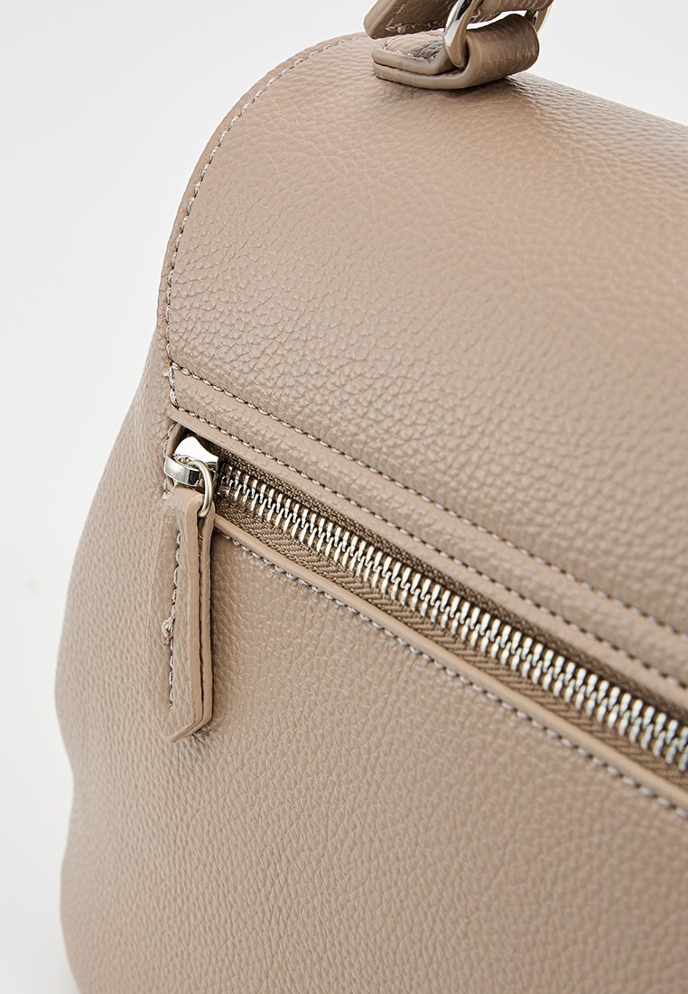 Sac à main en cuir beige de forme arrondie, surface texturée, avec un détail en zip argenté sur la poche avant.