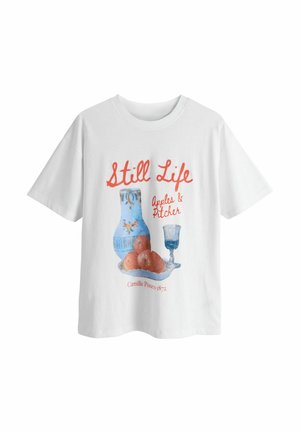 Hvid bomulds t-shirt med et stillebenprint af æbler, en blå kande og et glas, med rød tekst der siger "Still Life" og kunstnerens navn.
