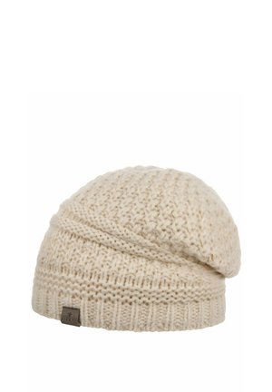 Cream-colored knitted wool beanie with textured stitch pattern and a small brown rectangular tag on the ribbed cuff.