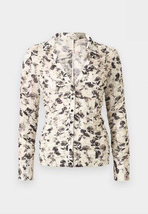 Hosszú ujjú, fodros gombos blúz fekete és szürke virágmintával, fehér alapon, gallérral és karcsúsított szabással.