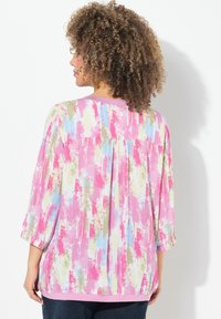 Pestrá blůza s abstraktním vzorem v růžové, modré a zelené barvě. Má tříčtvrteční rukávy a kulatý výstřih. Měkká látka s volným střihem.