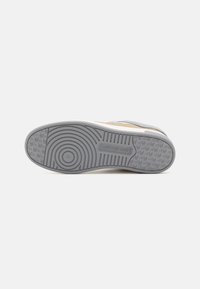 Le sneakers Calvin Klein Jeans presentano una suola in gomma grigia con schemi circolari e branding. La parte superiore combina tonalità pastello con una finitura testurizzata.