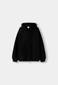 Sudadera negra con cremallera y capucha ajustable, mangas raglán, dos bolsillos frontales y una textura suave. Diseño simple y detalles mínimos.