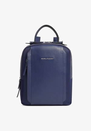 Mochila de cuero azul marino con asa superior, bolsillo frontal con cremallera, logo plateado "Piquadro" y cierre de doble cremallera sobre fondo blanco.