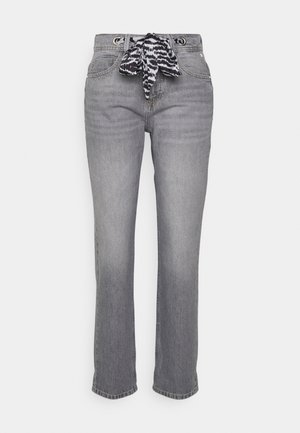 Jean gris à jambes droites avec poches avant et ceinture en tissu noir et blanc à motif, nouée à la taille.