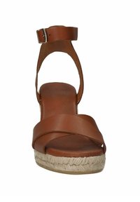 Braune Leder-Wedgesandalen mit überkreuzten Riemen, offenen Zehen und einem Knöchelriemen. Die mit Jute umwickelte Plateausohle sorgt für Textur und Höhe.