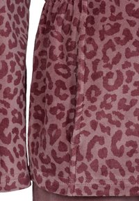 Leopard print stof i mauve og burgunder nuancer, med en tekstureret kordfløjsfinish og sammensnørede kantdetaljer.
