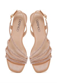 Strappy sandals with a light tan synthetic upper and textured footbed. Features shimmering accents along the straps and a square toe.