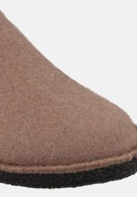 Bruine vilten pantoffel met een ronde neus, voorzien van een contrasterende zwarte zool en zichtbare stiksels langs de rand, wat zorgt voor een zachte textuur.