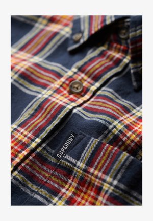 Geruit overhemd in marineblauw, rood, geel en wit. Gemaakt van katoen met knoopsluitingen en een geborduurd merkembleem op de zoom. Gestructureerd oppervlak.