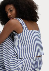 Blauwwit gestreepte katoenen top met brede bandjes, vierkante achterkant en een relaxte pasvorm. Complementair met vergelijkbaar gepatternde broek.