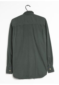Chemise à manches longues, tissu vert foncé, col boutonné, vue de dos montrant un empiècement, et accents en bouton doré sur les poignets.