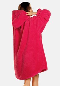 Puchaty, przytulny różowy hoodie w oversize'owym rozmiarze, wykonany z miękkiego materiału, z dużym kapturem, długimi rękawami i zaokrąglonym dołem.
