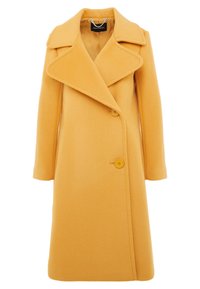 Pavimento giallo in lana con collo a pistagna, chiusura a bottoni doppi e tasche laterali. Di lunghezza media con una consistenza morbida.