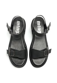 Sandales noires avec deux larges brides, accents de boucles et semelle texturée. La tige est en matériau lisse ressemblant à du cuir.