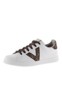 Sneaker blanche avec logo "V" en paillettes brunes, lacets bruns et accents de talon texturés. Dispose d'une semelle en caoutchouc et d'une surface lisse.
