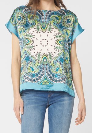 Kortærmet bluse med et livligt blågrønt paisleymønster på en cremefarvet baggrund, med en løs pasform og glat tekstur.