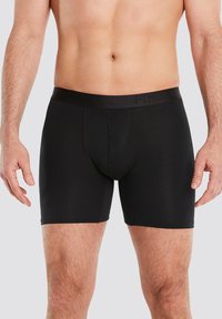 Schwarze Boxer-Briefs aus einem glatten, dehnbaren Stoff. Mit einem breiten schwarzen elastischen Bund mit dezentem Logo-Detail und figurnahem Schnitt.