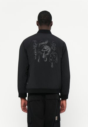 Black bomber jacket with a matte finish, featuring a large graphic print on the back, text, and a ribbed collar and cuffs. Casual fit.