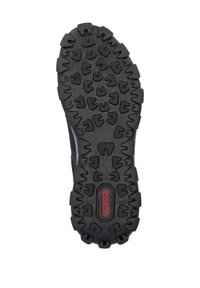 Schwarze Gummisohle mit tiefen Profilmustern, featuring einem zentralen Branding-Bereich und einer strukturierten Oberfläche für Grip und Haltbarkeit.