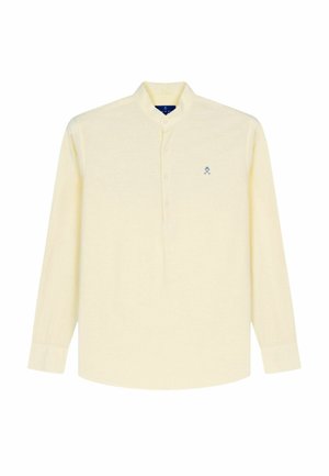 Chemise crème à manches longues avec boutons, col mandarin et petit logo bleu brodé sur la poitrine gauche.