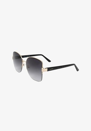 Occhiali da sole quadrati neri e oro con lenti scure sfumate e aste nere con motivo e logo Guess dorato.