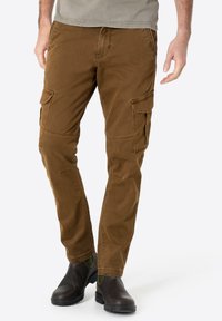 Brown cargo pants made of soft cotton, featuring side pockets, a straight leg design, and reinforced seams, paired with dark ankle boots.