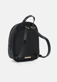 Černý batoh z umělé kůže se zlatými detaily, kulatý tvar, horní ucho a nastavitelné popruhy; obsahuje embosované zdobení.