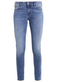 Tighta jeans i ljusblå denim, med hög midja, femfickorsdesign och subtila blekningar. Slät textur med sömnadsdetaljer.