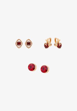 Tre par guldringe med røde ædelsten: firkantet skåret med hvide detaljer, rundskåret med guldbladsdetalje og simple runde ørestikker.
