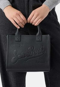 Borsa nera in pelle con superficie testurizzata, caratterizzata dal marchio "Saint Barth" in rilievo e manici corti, posta su uno sfondo scuro.