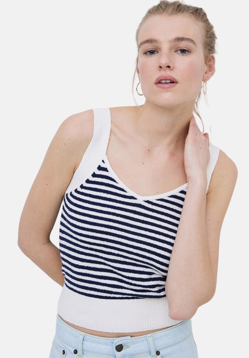 Camiseta sin mangas a rayas en azul marino y blanco, con escote en V y dobladillo acanalado. Fabricada con una suave tela texturizada para mayor comodidad.