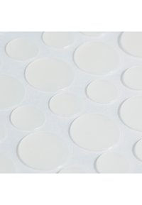 Des points adhésifs transparents sur un fond blanc, de tailles et de formes circulaires variées, avec une texture lisse et une finition brillante. Idéaux pour l'étiquetage ou l'artisanat.