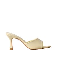 Mule couleur crème à bout ouvert avec un talon fin de hauteur moyenne et une tige rembourrée, vue de profil sur fond blanc.