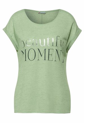 Lichtgroen T-shirt met korte mouwen en een ronde hals. Op de voorkant staat in metaalachtige zilveren letters de tekst "beautiful MOMENT." Zachte textuur.