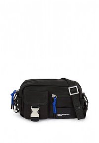 Černá taška přes rameno z látky s několika kapsami, modrými kovovými detaily, stříbrnou přezkou a nastavitelným popruhem. Kompaktní obdélníkový tvar.