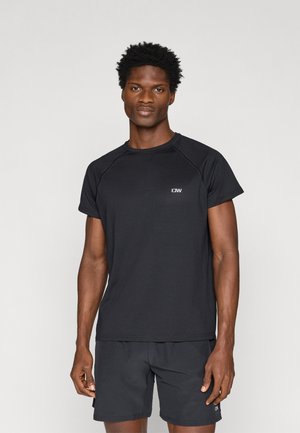 Zwart sportshirt met korte mouwen, van textuurstof, en een klein logo op de borst. Gecombineerd met zwarte shorts, beide in een nauwsluitend ontwerp.