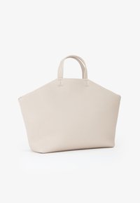 Grande borsa tote beige con finitura texturizzata, dotata di due manici corti e di una forma triangolare ampia. Nessun hardware o accento visibile.