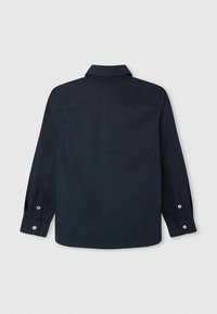 Laivastonsininen nappipusero, jossa on pitkät hihat, kaulus ja hopeiset napit hihansuissa; sileä kangas, suora leikkaus ja vahvistettu ommeltu yksityiskohta.