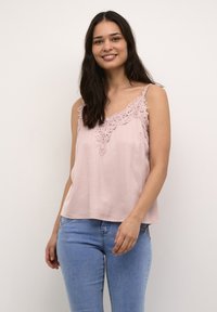 Pink camisole with lace detailing along the neckline, featuring thin straps and a relaxed fit, paired with light blue jeans.