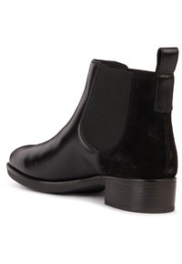Botte Chelsea en cuir noir et daim avec panneaux latéraux élastiques et un petit talon empilé, vue de côté.
