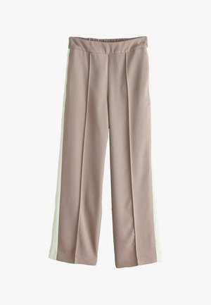 Világosbarna, széles szárú nadrág fehér oldalsávokkal, rugalmas derékrésszel és elől gyűrődéssel, fehér háttéren szétterítve.